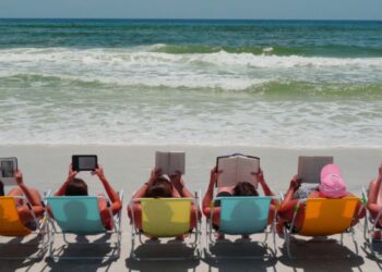 Férias de Verão: chinelo no dedão do pé e livro na mão