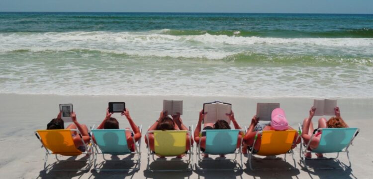 Férias de Verão: chinelo no dedão do pé e livro na mão